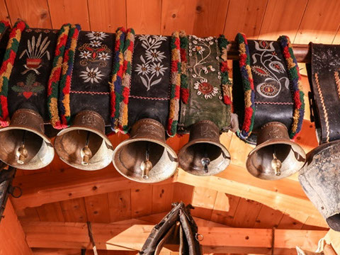 Traditionelle Kuhglocken mit bestickten Riemen als Hüttendekoration