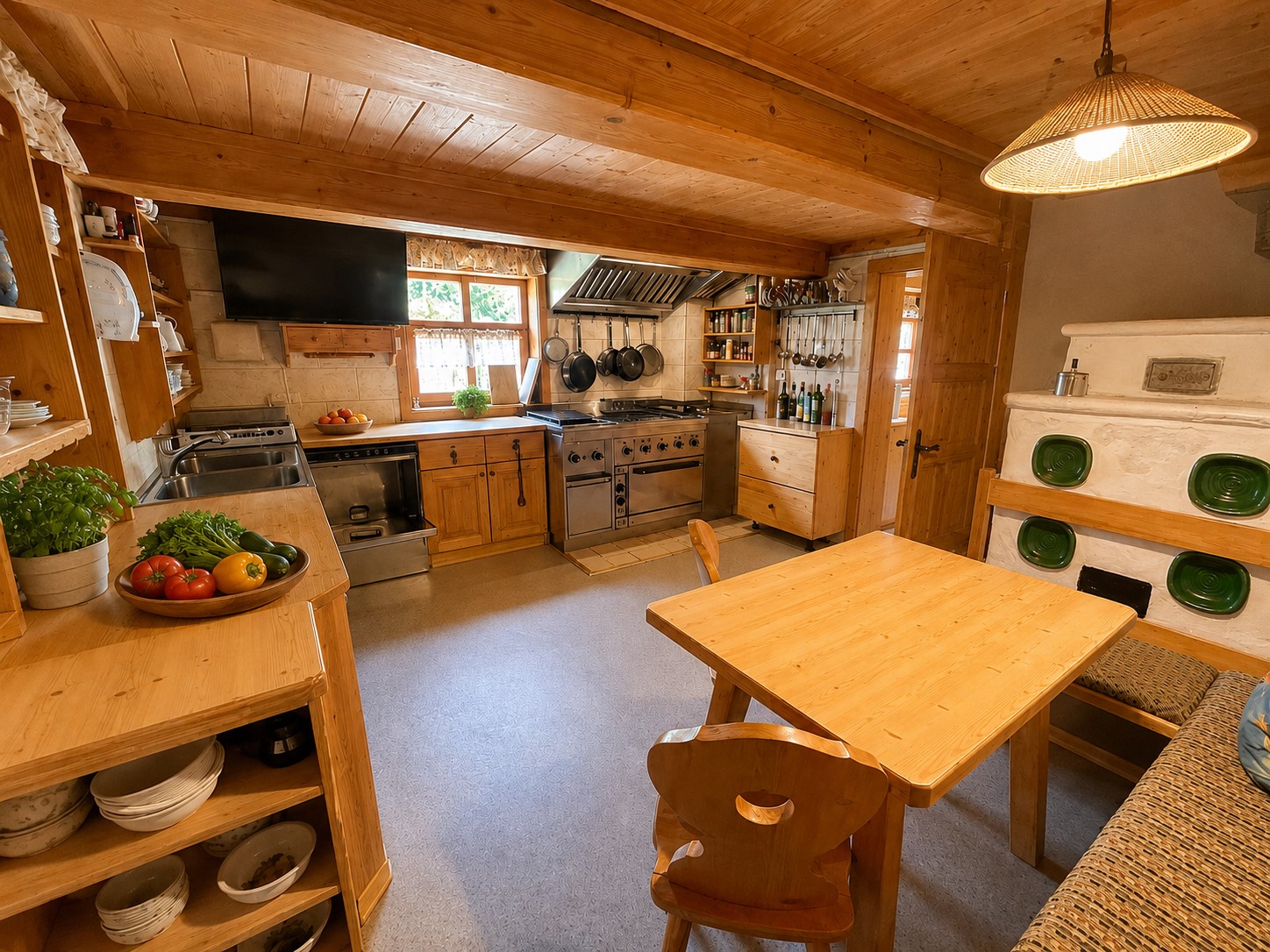 Küche der Hütte mit Holzfronten, großem Herd und Essplatz
